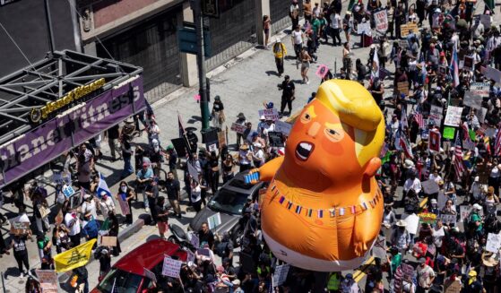 A 20-foot-tall balloon of President Donald Trump in a diaper is seen among people taking part in a "No Kings" protest in Los Angeles, California, on June 14, 2025 as Trump presides over a military parade in Washington, D.C.